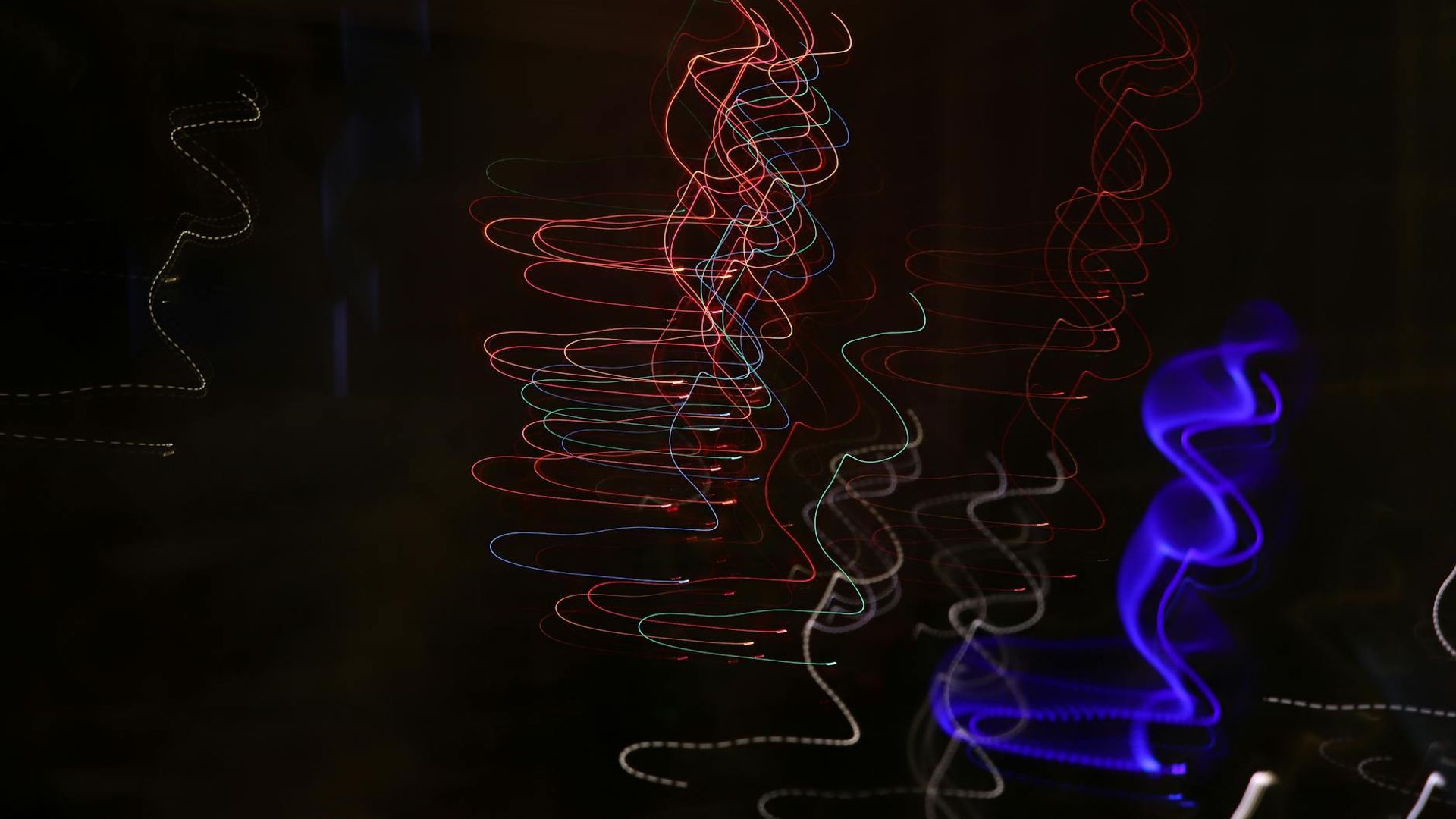 Abstract dark background with neon red light trails suggesting fluid motion.